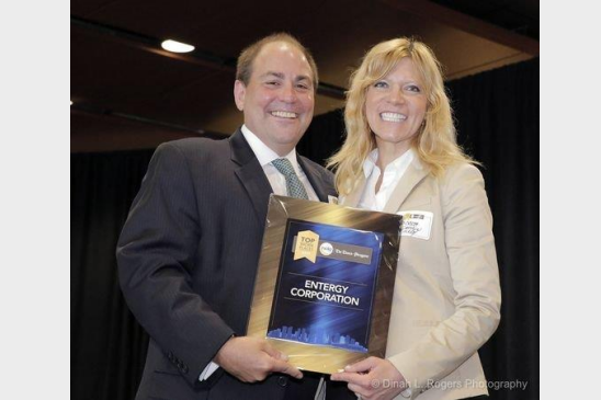 Andrea Coughlin Rowley, Entergy's senior vice president of human resources, accepts the award for being a Top Workplace in the greater New Orleans area from Tim Williamson, president of NOLA Media Group.
